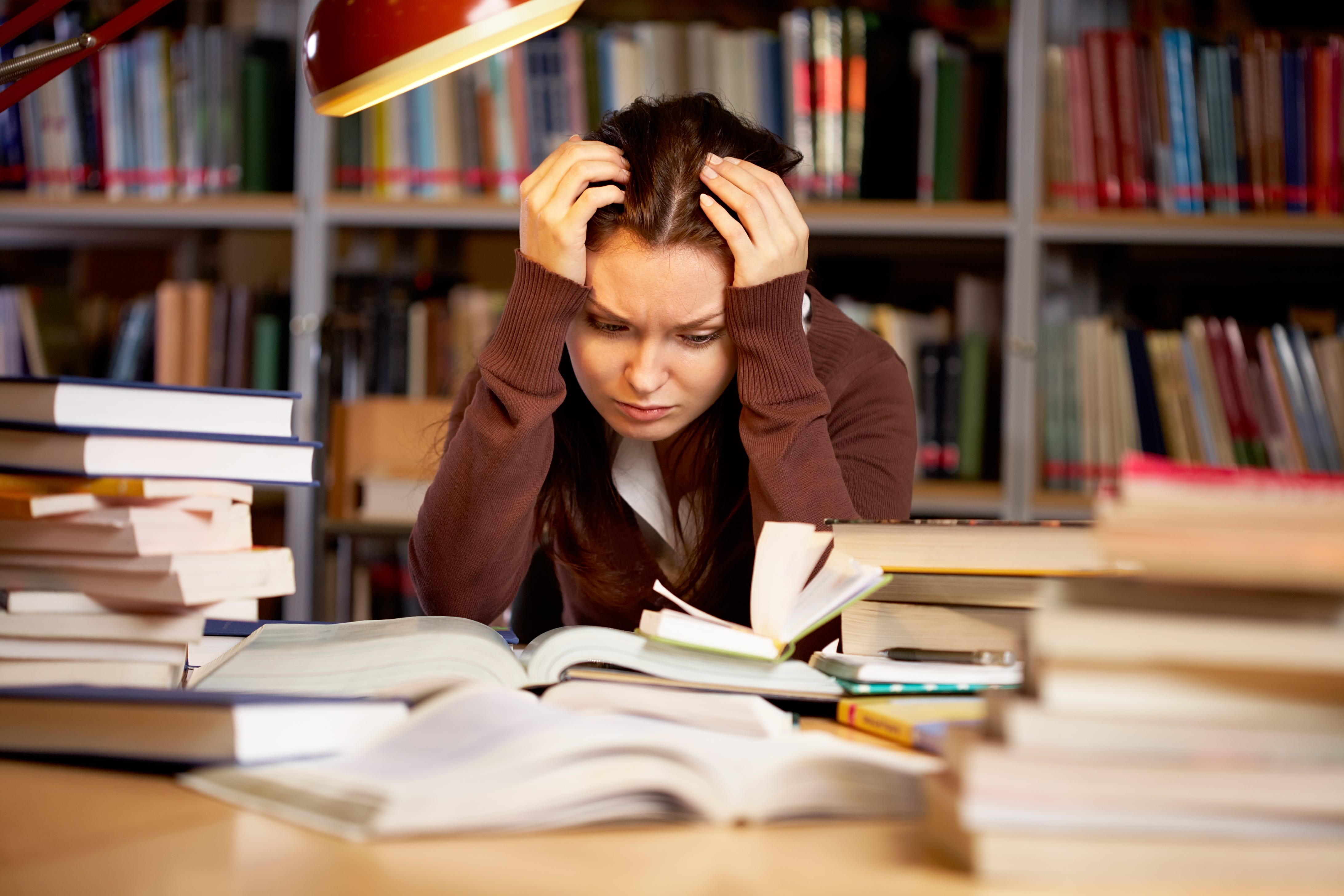 Книги много проблем. Стресс на учебе. Стресс у студентов. Проблемы с учебой. Человек готовится к экзамену.
