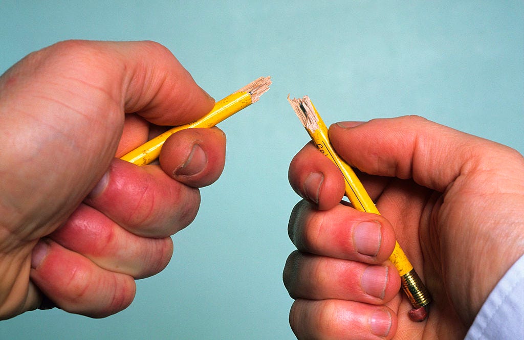 Harrassed businessman snapping pencil in frustration